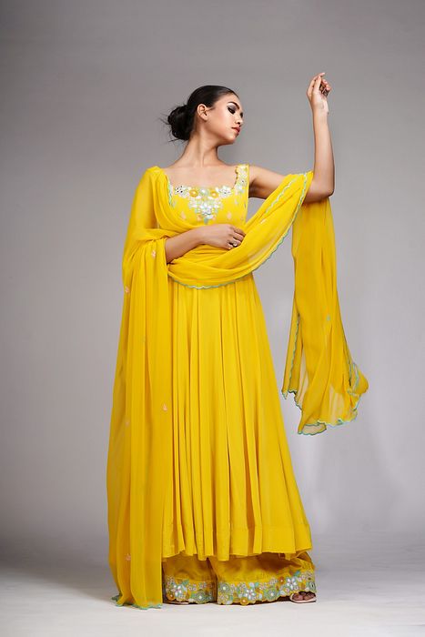 A model showcasing Thread Mirror Work Anarkali In Yellow by Shruti S Label from Shruti S Label's collection